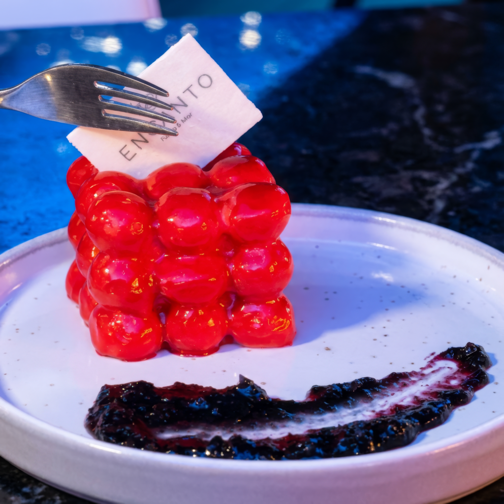 Postre simétrico de cerezas siendo cortado con un tenedor