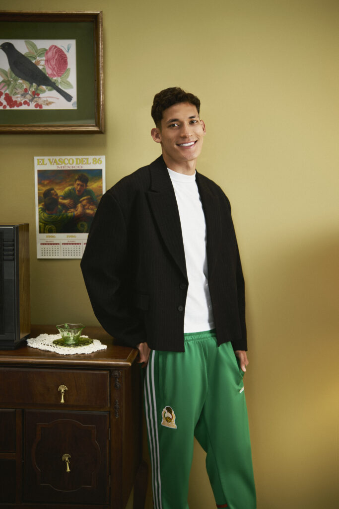 Retrato de Jesus Orozco usando una chamarra negra, una playera blanca y un pans verde adidas   inspirados en el  Mundial 