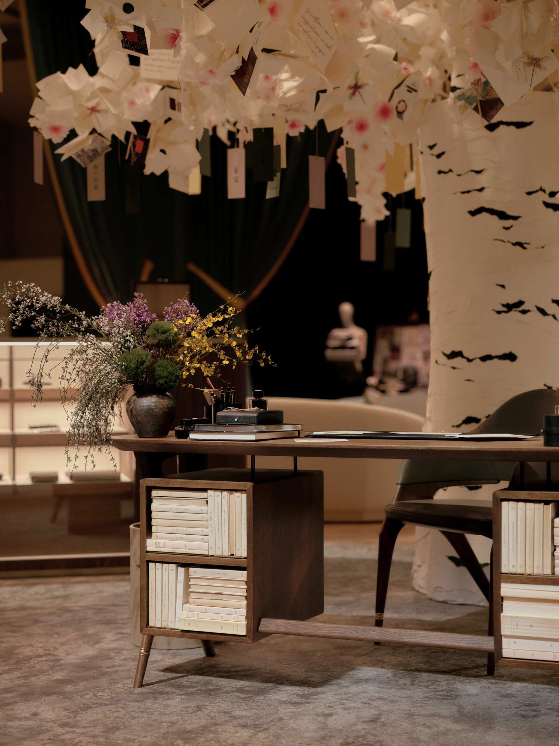 Showroom Montblanc con un árbol forrado en color blanco y un escritorio marrón