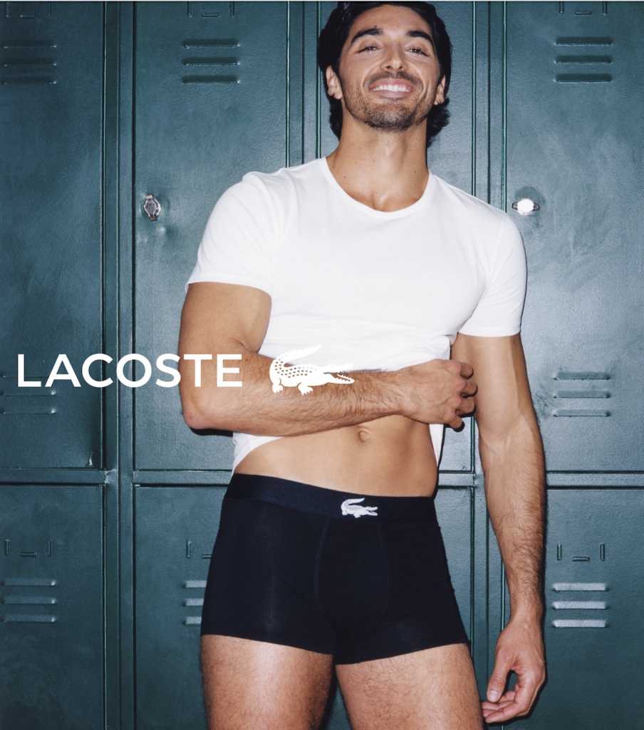 Taylor Zakhar Perez con boxer de Lacoste y una playera blanca recardado en casilleros