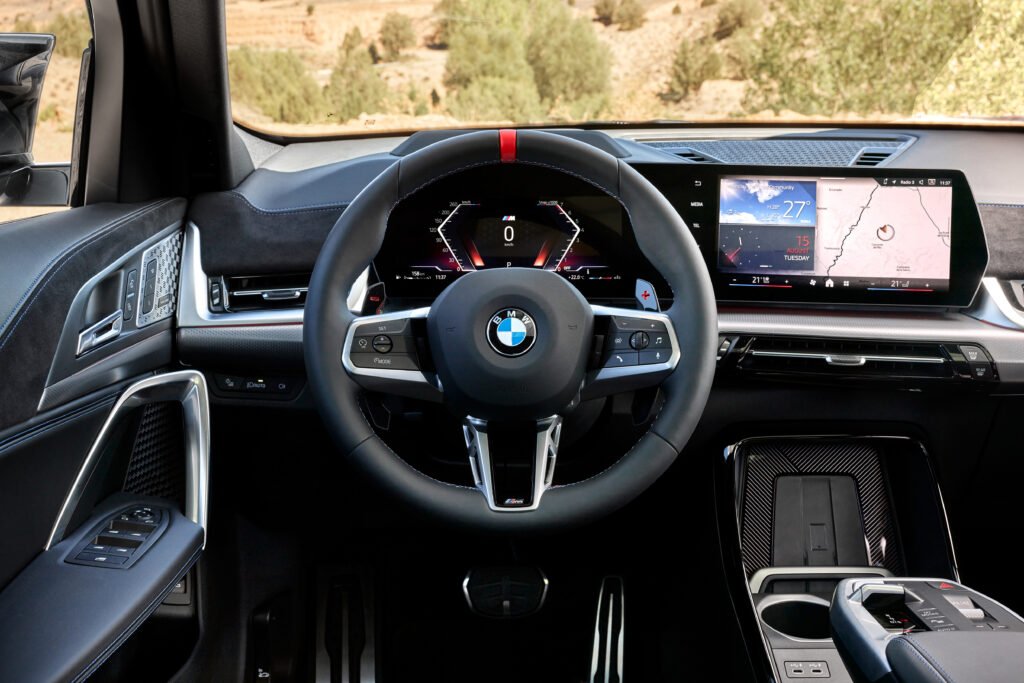 Interior de la camioneta BMW iX2 en negro y con una pantalla grande 