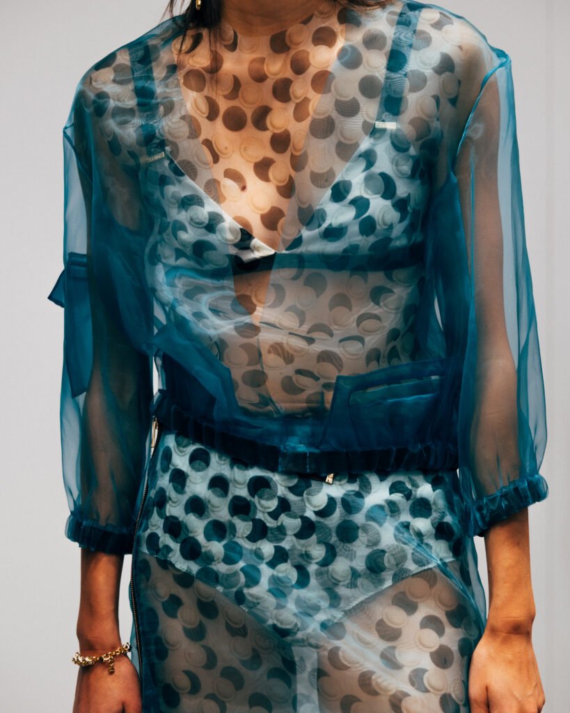 imagen con close up a look de FENDI SS26 en Backstage, prendas con transparencias y formas geométricas. propuesta global de la colección